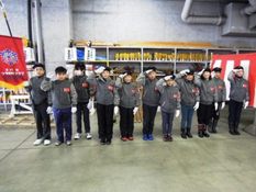 少年消防クラブの子どもたちが整列し、敬礼している様子