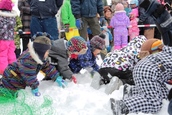 子どもたちが、こども宝探しゲームで雪の中からカプセルを探している様子