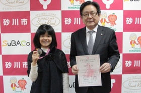 市長が賞状を持ち、田中邑奈(ゆうな)さんがメダルを持って記念撮影を記念撮影をしている様子