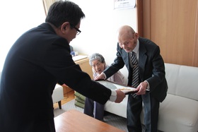 市長から石川さんにお祝いを贈呈しているところ
