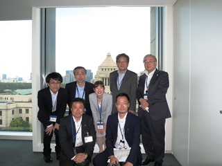 議員会館から見える国会議事堂を背景に北海道市長会事務局など同行した方との写真