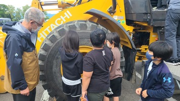 建設機械の大型タイヤに触れる子どもたち