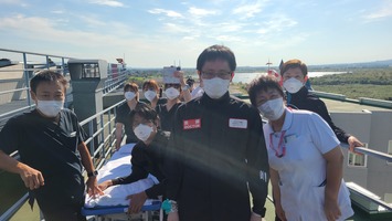 ヘリが停止するまでスロープで待機する救命救急センター川原センター長(写真中央)と救命救急スタッフ