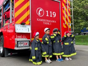 消防車の後ろで整列している園児