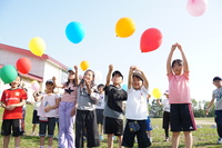 子どもが風船を飛ばす写真