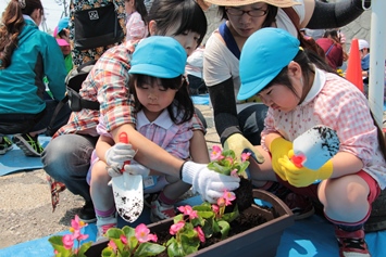 お母さんと一緒に花を植えています